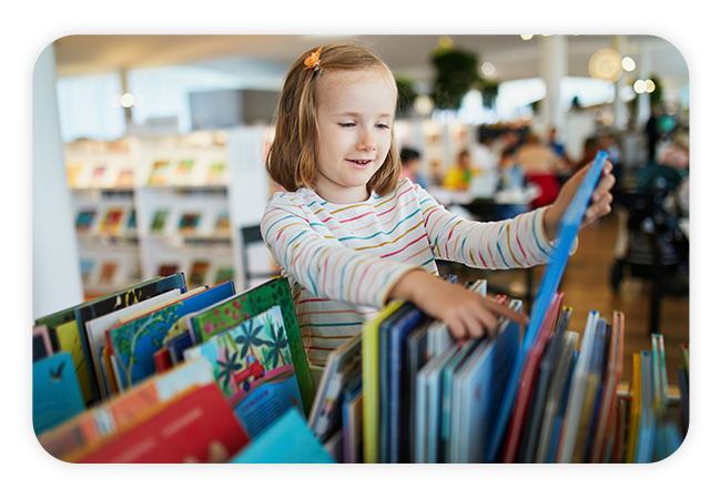 a young girl browsing a row of books