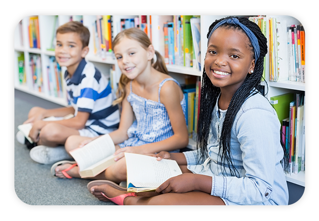children sitting crosslegged reading books on the library carpet