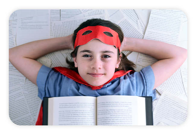 a child lying on his back with a book open on their chest, wearing a superhero costume