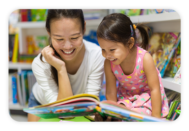 a young woman and a little girl reading a book together
